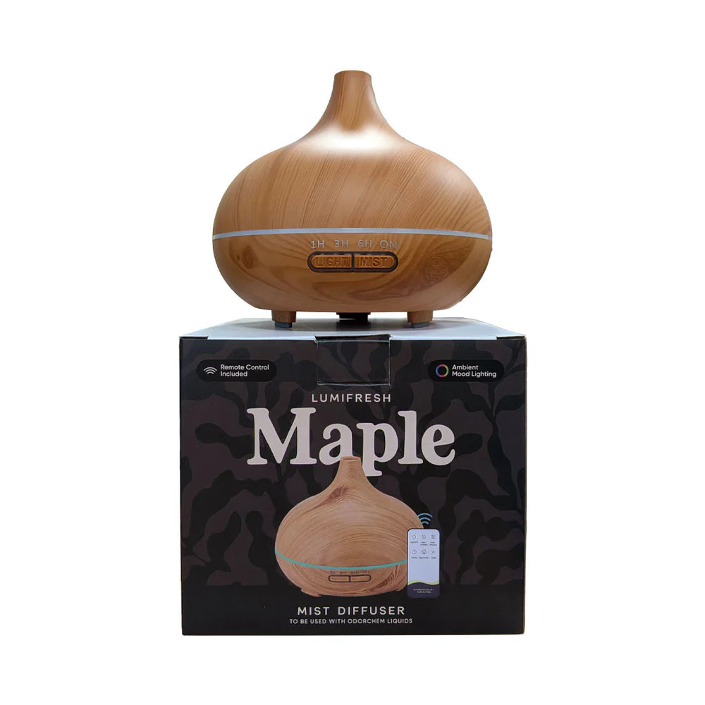 A wooden essential oil mist diffuser shown on top of its black retail box. The diffuser has a light brown wood-grain finish with a small LED light band and a central control panel.
