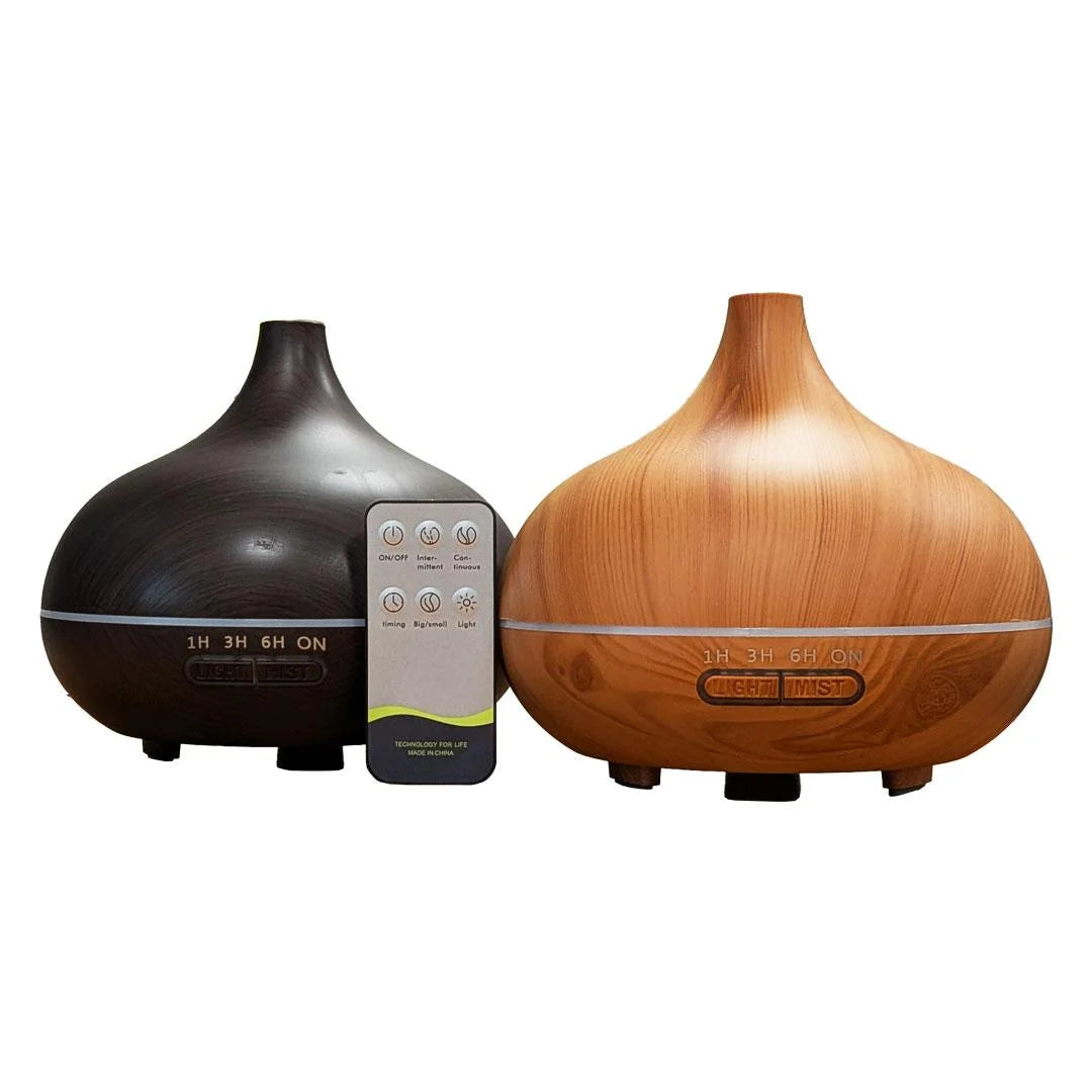 Two tabletop diffusers on a white background: one matte dark brown/black and one wood-grain brown, with a small remote control standing between them.