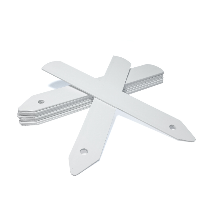 A set of white plastic plant labels laid out in an X-shape on a plain background.