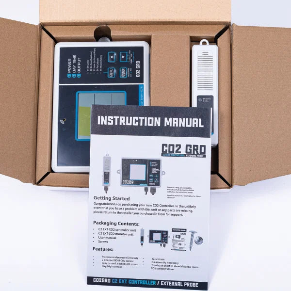 CO2 controller with external probe and instruction manual in an open cardboard box.